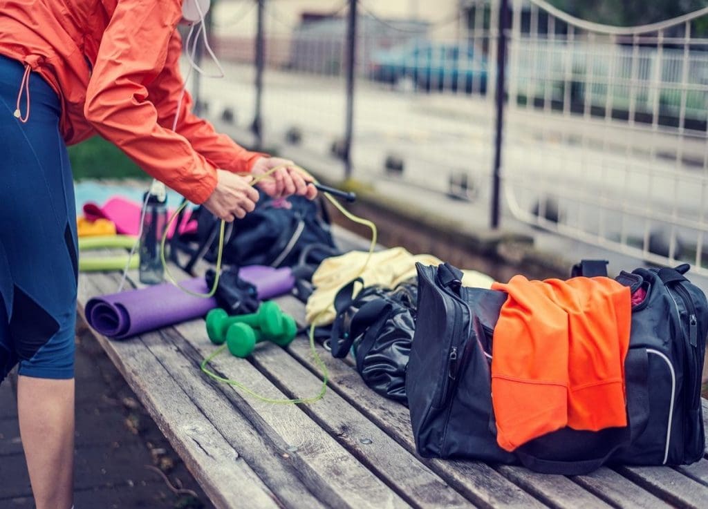 a person collecting his gym accessories in bag.