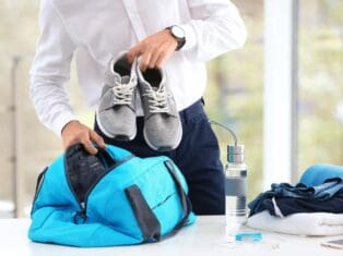 a man putting his shoes in gym bag.